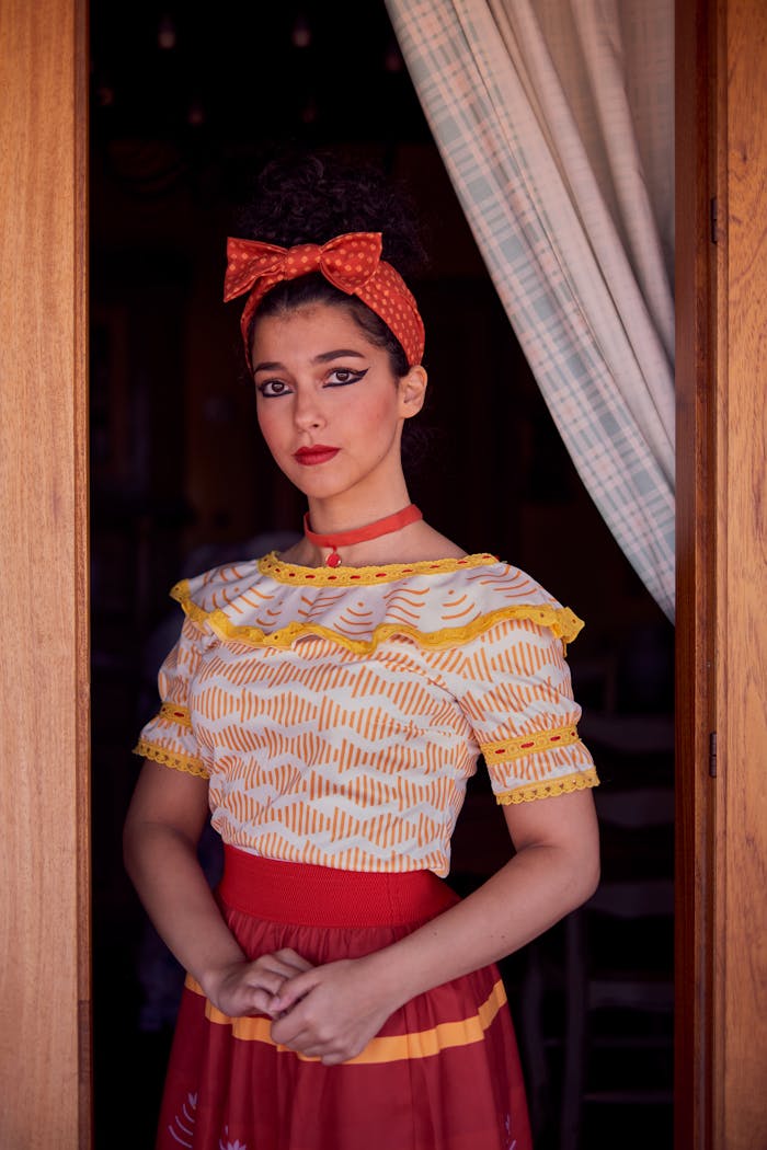 A woman in traditional Sicilian dress poses elegantly in a doorway in Bagheria, Sicily.