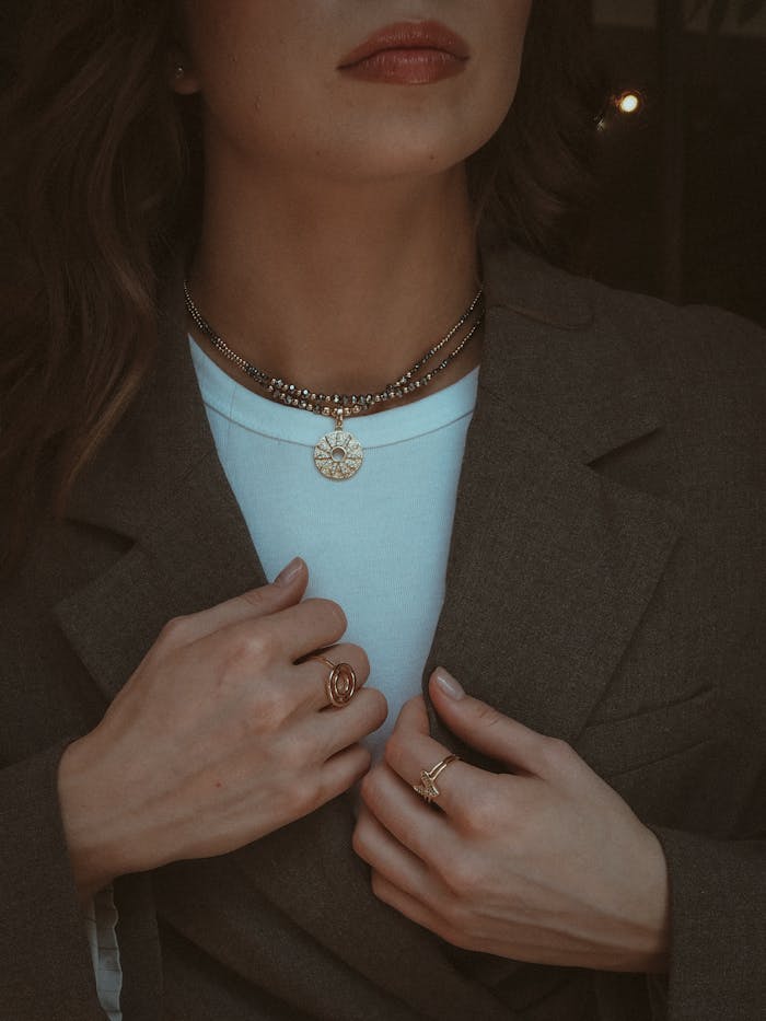 Fashionable woman wearing jewelry and a blazer, highlighting style and elegance.